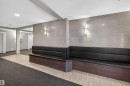 Lobby featuring built-in black seating, textured wall paneling with sconce lighting, and mixed tile and carpet flooring - 215 6084 Stanton Drive, Edmonton, AB  - Indoor Photo Showing Other Room 