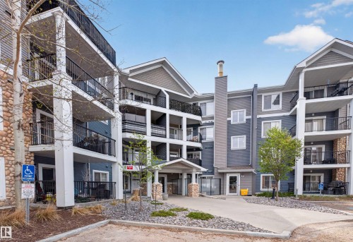 Multi-story residential building featuring two-tone siding, stone accents, and multiple private balconies with black railings - 215 6084 Stanton Drive, Edmonton, AB - Outdoor With Balcony With Facade