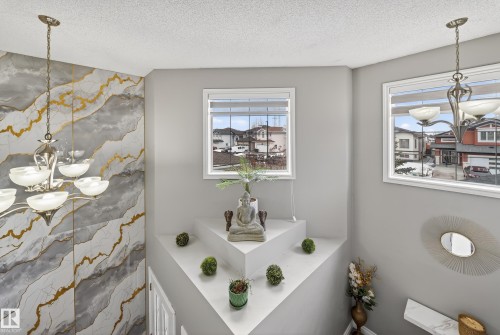 This property features two windows providing views of the surrounding neighborhood and a decorative wall with a gold and grey marble-like pattern - 3517 25 Street, Edmonton, AB - Indoor Photo Showing Bathroom