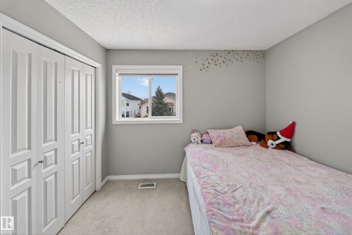 This room features light grey walls, a white window frame, and white bifold closet doors - 3517 25 Street, Edmonton, AB - Indoor Photo Showing Bedroom