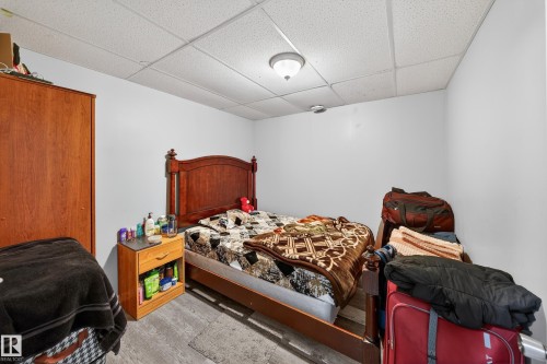 This room features light grey walls and a drop-tile ceiling with an overhead light fixture - 3517 25 Street, Edmonton, AB - Indoor Photo Showing Bedroom