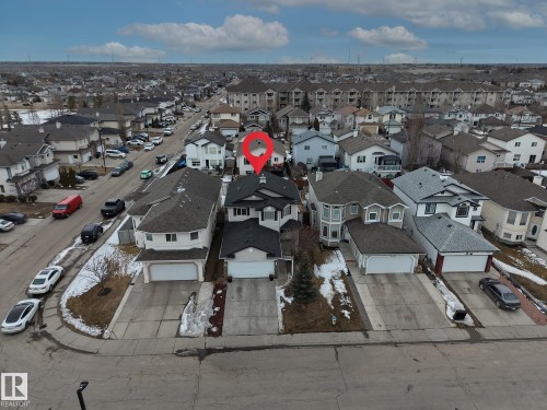 This property features a prominent residential structure with a dark roof and light-colored siding, complemented by an attached garage with a concrete driveway - 3517 25 Street, Edmonton, AB - Outdoor