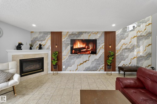 This living space features a corner fireplace with a mantel, complemented by light-colored tile flooring - 3517 25 Street, Edmonton, AB - Indoor Photo Showing Living Room With Fireplace