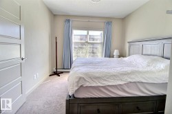 Neutral-toned room with light-colored carpeting and a window featuring light blue drapes - 