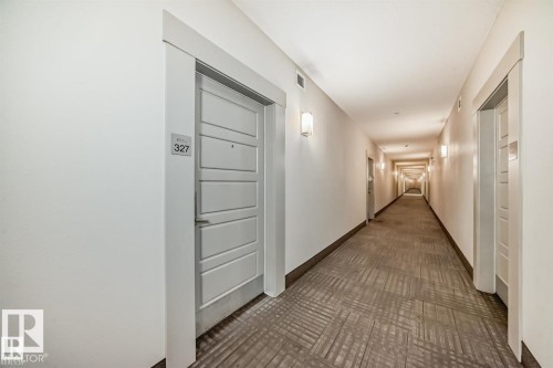 Long hallway featuring gray patterned carpeting and white walls - 327 508 Griesbach Parade, Edmonton, AB - Indoor Photo Showing Other Room
