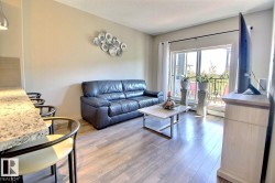 Living area with light wood-finish flooring and a sliding glass door to the exterior - 