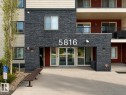 Building entrance featuring a stacked stone facade, large building numbers, and glass double doors - 422 5816 Mullen Place, Edmonton, AB  - Outdoor 