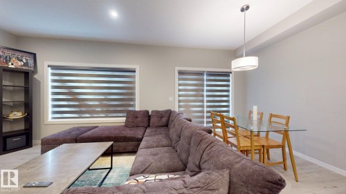 The living area features light-colored walls, recessed lighting, and a window with horizontal blinds - 607 31 Avenue, Edmonton, AB - Indoor Photo Showing Living Room