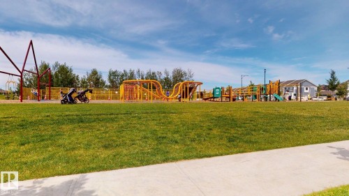 Expansive green space with a playground featuring various play structures - 607 31 Avenue, Edmonton, AB - Outdoor
