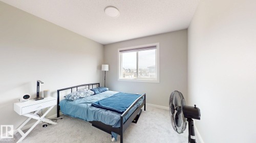 This room features neutral-toned walls, a window providing natural light, and light-colored carpet - 607 31 Avenue, Edmonton, AB - Indoor Photo Showing Bedroom