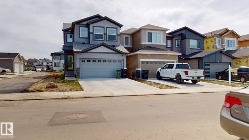 The property features a two-story exterior with grey siding and a light-colored front door, complemented by a two-car garage - 607 31 Avenue, Edmonton, AB - Outdoor With Facade