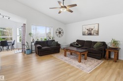 Living area featuring vaulted ceilings and light wood-finish flooring - 