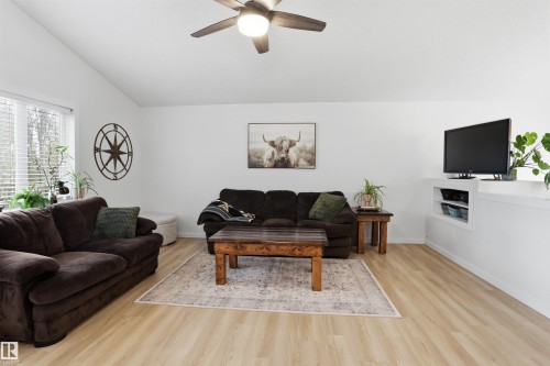 Living area with vaulted ceiling and wood-finish flooring - 396 Kananaskis Way, Devon, AB - Indoor Photo Showing Living Room