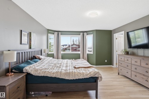 Bedroom featuring light wood-finish flooring and a multi-tone paint scheme - 396 Kananaskis Way, Devon, AB - Indoor Photo Showing Bedroom