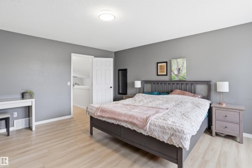 Room featuring light wood-finish flooring, neutral gray walls, and white baseboards - 396 Kananaskis Way, Devon, AB - Indoor Photo Showing Bedroom