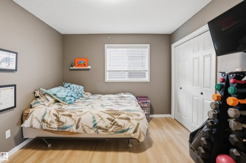 Room featuring wood-finish flooring, a window with blinds, and neutral wall paint - 396 Kananaskis Way, Devon, AB - Indoor Photo Showing Bedroom