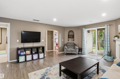 Spacious living area featuring wood-finish flooring, recessed lighting, and a neutral wall palette - 396 Kananaskis Way, Devon, AB - Indoor Photo Showing Living Room With Fireplace