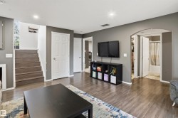 Open concept interior featuring wood-finish flooring, recessed lighting, a white six-panel door, and an arched entry - 