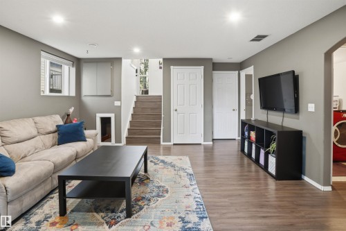 Spacious living area featuring wood-finish flooring, recessed lighting, and a neutral wall palette - 396 Kananaskis Way, Devon, AB - Indoor Photo Showing Living Room