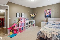 Carpeted bedroom featuring neutral wall paint, a built-in shelving unit, and a standard door frame opening to a separate space with wood-finish flooring - 