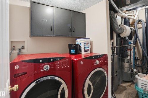 Laundry area featuring wall-mounted cabinetry, washer and dryer hookups, and a built-in utility closet housing mechanical equipment - 396 Kananaskis Way, Devon, AB - Indoor Photo Showing Laundry Room