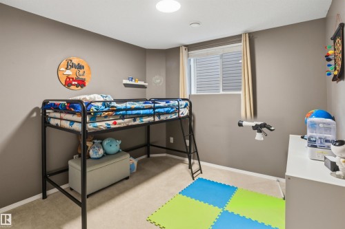 Carpeted room featuring neutral wall tones, a built-in window with horizontal blinds, and a flush-mount ceiling light fixture - 396 Kananaskis Way, Devon, AB - Indoor Photo Showing Other Room