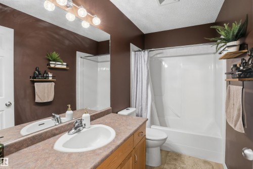 Bathroom featuring a single vanity with a laminate countertop, an integrated sink, and a chrome faucet - 396 Kananaskis Way, Devon, AB - Indoor Photo Showing Bathroom