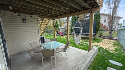 Covered concrete patio with overhead string lighting, providing exterior illumination - 396 Kananaskis Way, Devon, AB - Outdoor With Deck Patio Veranda With Exterior