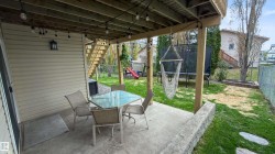 Covered concrete patio with overhead string lighting, providing exterior illumination - 