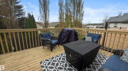 Expansive outdoor deck featuring wood flooring and matching wood railing - 