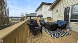 Expansive wooden deck with a built-in railing, siding exterior, and exterior wall sconce - 