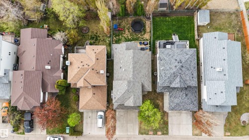 Aerial perspective showcasing three residential properties with varied rooflines and asphalt shingles - 396 Kananaskis Way, Devon, AB - Outdoor