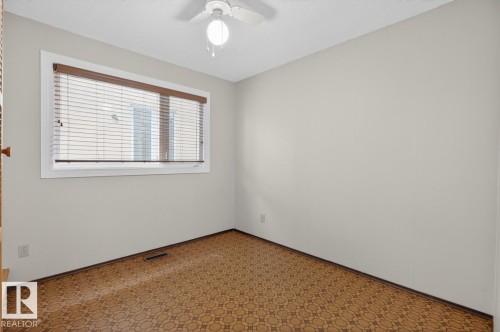 Room featuring light neutral painted walls, patterned flooring, and a single window with blinds and a wood valance - 8911 84 Avenue, Edmonton, AB - Indoor Photo Showing Other Room