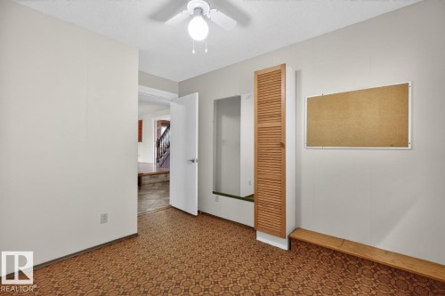 Room with patterned flooring, a ceiling fan, and a built-in louvered cabinet - 8911 84 Avenue, Edmonton, AB - Indoor Photo Showing Other Room