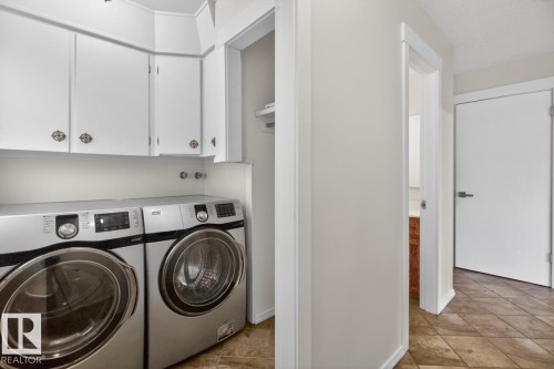 Dedicated laundry area featuring white upper cabinetry and a tiled floor - 8911 84 Avenue, Edmonton, AB - Indoor Photo Showing Laundry Room