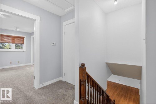 Stairwell featuring wood-finish flooring and a wood baluster railing - 8911 84 Avenue, Edmonton, AB - Indoor Photo Showing Other Room
