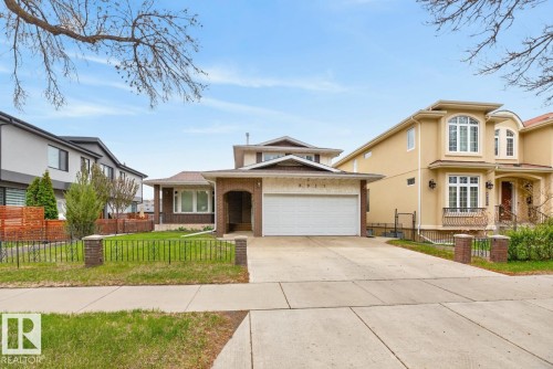Traditional-style home featuring a two-car garage, brick facade accents, and a large driveway - 8911 84 Avenue, Edmonton, AB - Outdoor With Facade