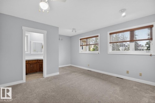 Carpeted room featuring multiple windows with wood-tone blinds, a ceiling fan, recessed lighting, and an alcove with a built-in wood vanity - 8911 84 Avenue, Edmonton, AB - Indoor Photo Showing Other Room