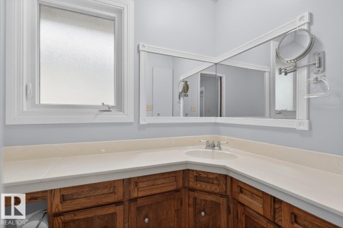 Corner vanity featuring a drop-in sink, neutral countertop, and wood-finish cabinetry - 8911 84 Avenue, Edmonton, AB - Indoor