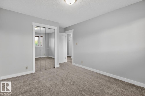 Carpeted interior space featuring light grey walls and white baseboards - 8911 84 Avenue, Edmonton, AB - Indoor Photo Showing Other Room
