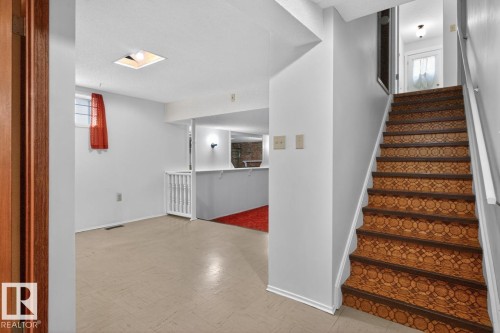 Staircase featuring patterned risers and a white handrail - 8911 84 Avenue, Edmonton, AB - Indoor Photo Showing Other Room