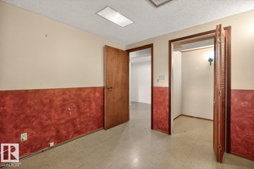 Room with neutral upper walls and a lower textured red wall treatment - 8911 84 Avenue, Edmonton, AB - Indoor Photo Showing Other Room