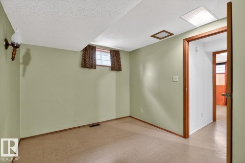 Room featuring light green walls, a single window with brown valances, and wood-finish flooring - 8911 84 Avenue, Edmonton, AB - Indoor Photo Showing Other Room