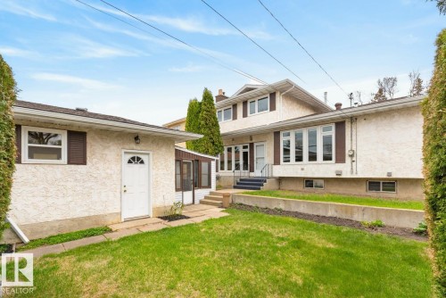 Stucco exterior home with multiple windows and dark shutters - 8911 84 Avenue, Edmonton, AB - Outdoor