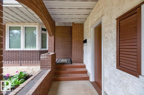 Covered front entry featuring brick construction and stucco siding - 8911 84 Avenue, Edmonton, AB - Outdoor With Exterior