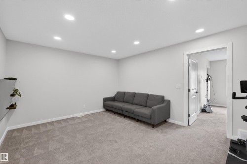 Spacious room featuring neutral carpeting, recessed ceiling lighting, and a white interior door - 332 Juniper Cove, Leduc, AB - Indoor