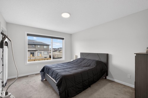 Bedroom featuring a large window, neutral carpeting, recessed lighting, and light gray wall tones - 332 Juniper Cove, Leduc, AB - Indoor Photo Showing Bedroom