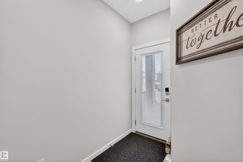 White entry door with frosted glass panel, recessed lighting, and light gray wall paint - 332 Juniper Cove, Leduc, AB - Indoor Photo Showing Other Room