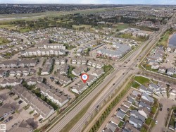 Aerial overview of a residential neighborhood with detached homes, townhomes, and a multi-story apartment building - 