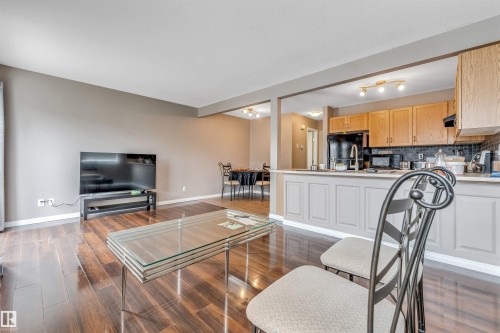 Open-concept living space featuring rich wood-finish flooring, neutral wall tones, and recessed lighting - 135 150 Edwards Drive, Edmonton, AB - Indoor Photo Showing Living Room